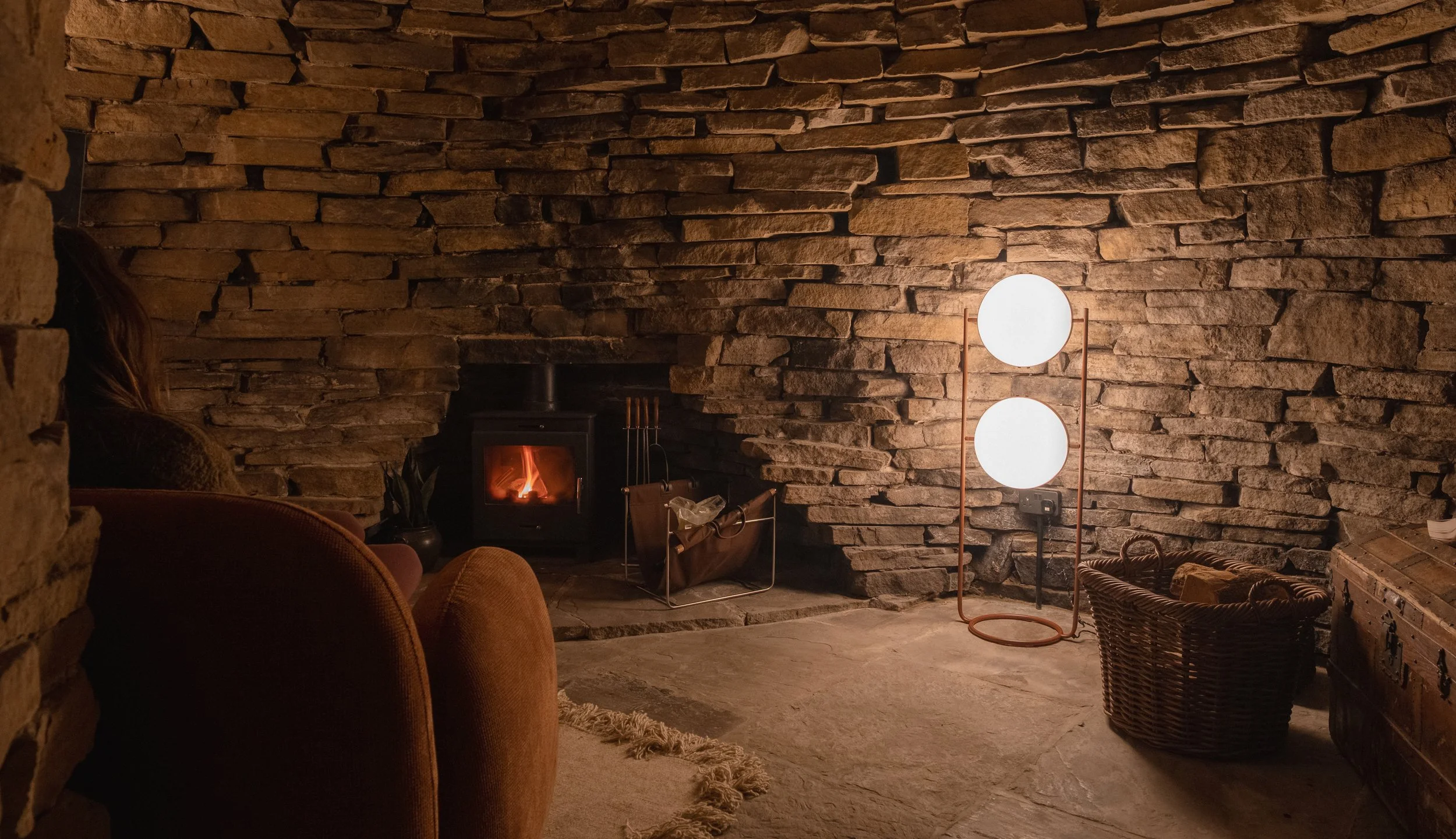 Curl up beside the fire in Underhill’s atmospheric stone cave, a cosy hidden space designed for peaceful evenings indoors