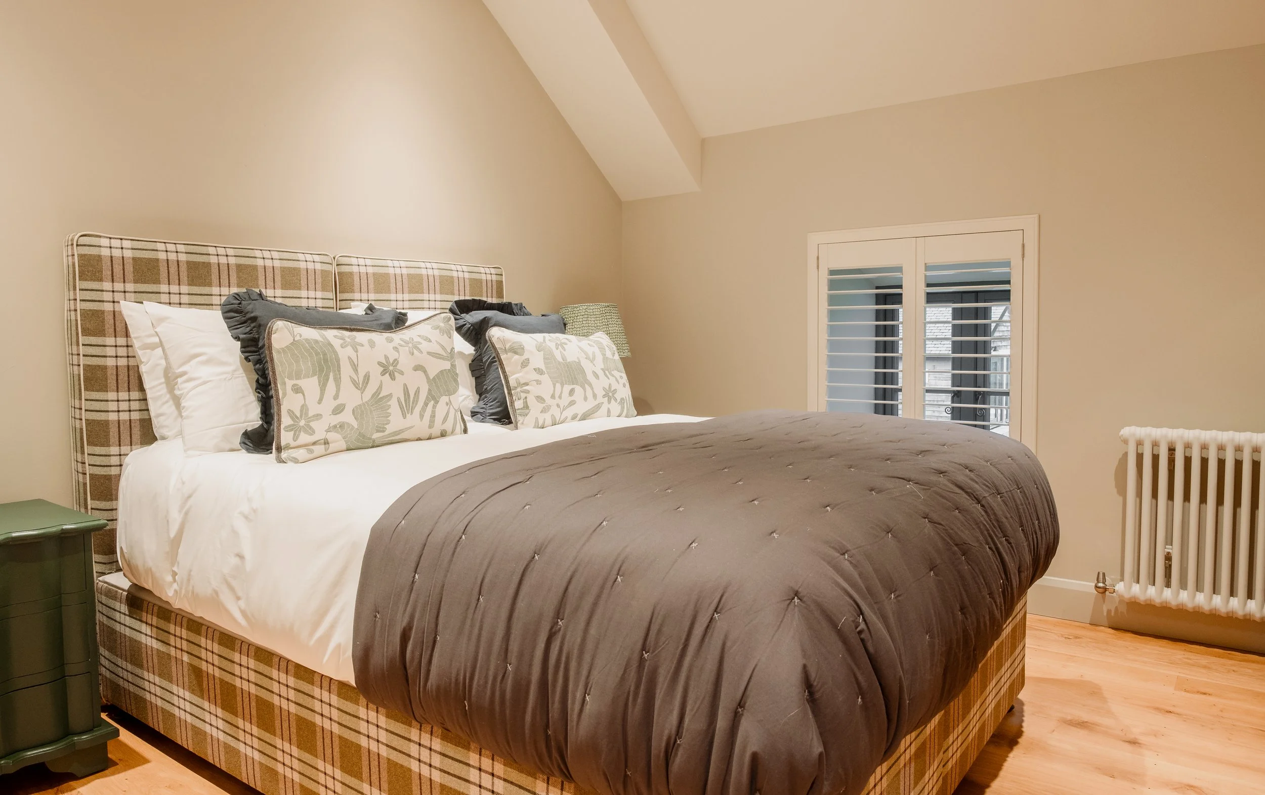 the second bedroom offers a warm and inviting retreat, layered with rich textures, soft neutrals, and gentle lighting. 