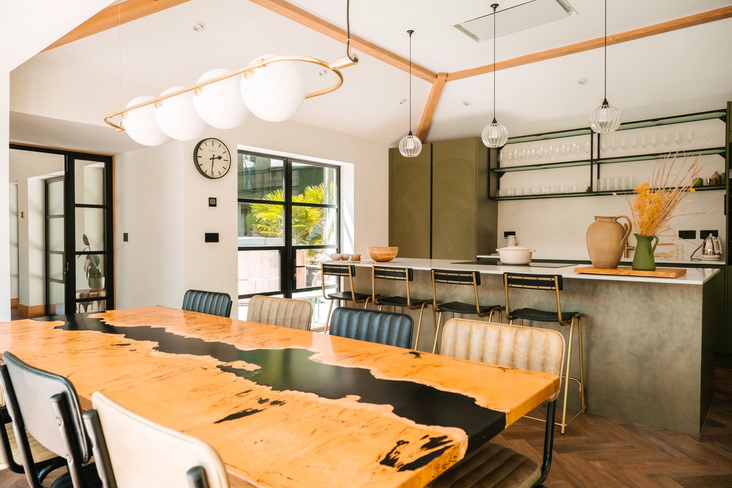 The large dining table invites everyone to gather, linger and share unhurried meals together. Framed by soft light and open space, it is the heart of the home in every season.