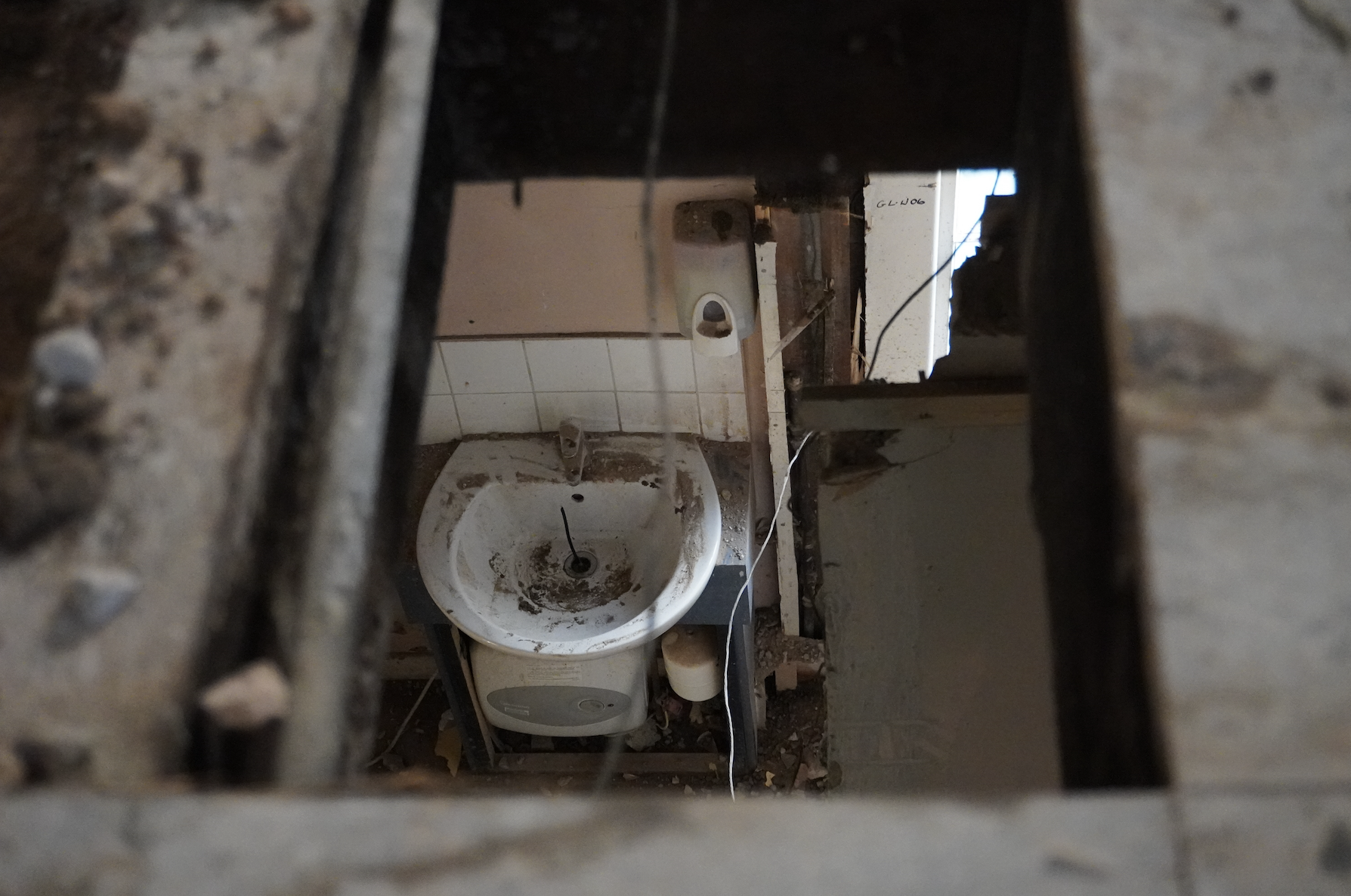 looking down through the upper floor to an old downstairs toilet