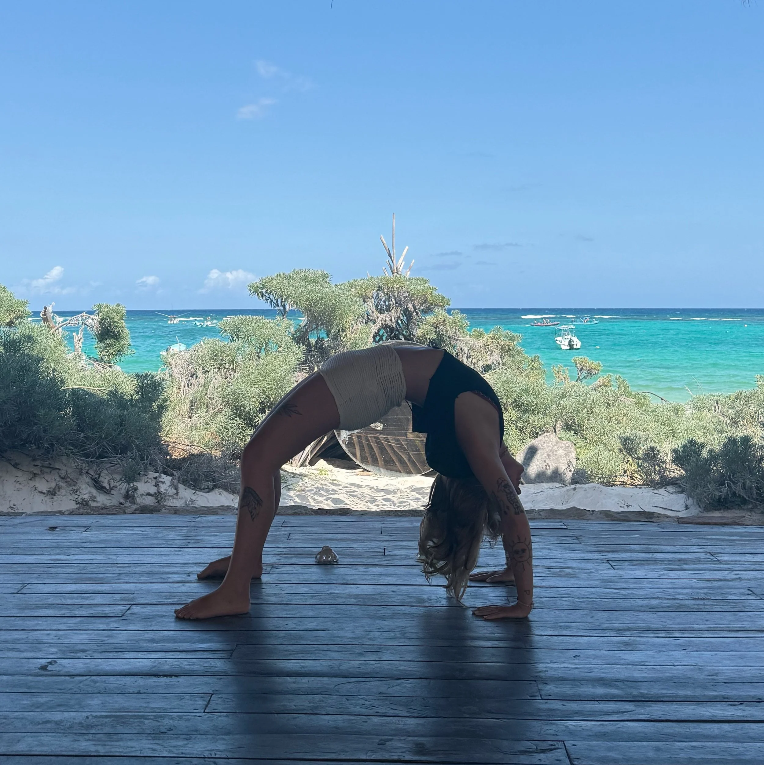 Yoga Teacher doing a wheel pose on the beach in Tulum
