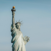 Close-up of the Statue of Liberty with a clear blue sky background.