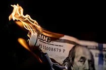 A hundred-dollar bill on fire with flames coming from one end.