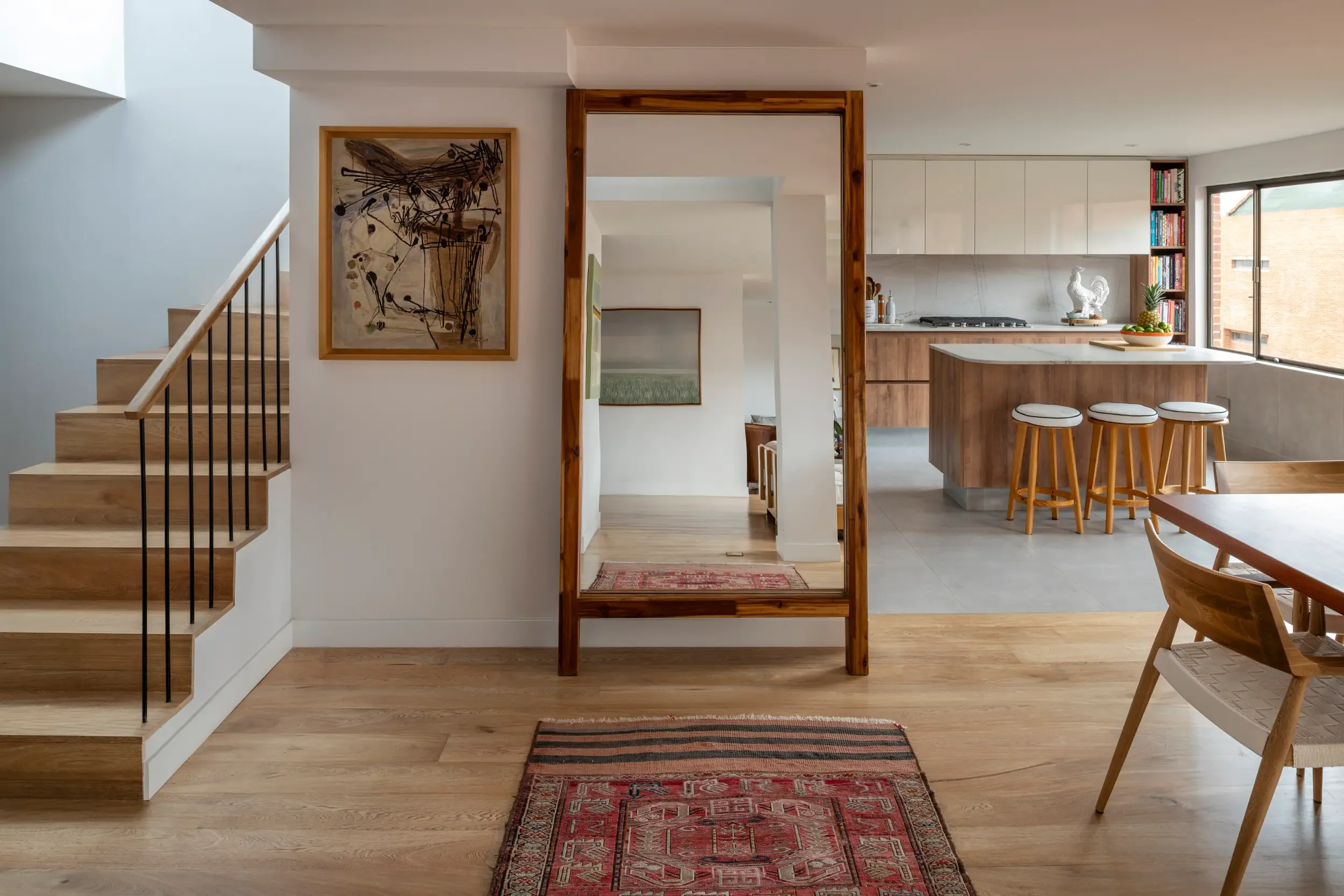 Bright renovated space in Bogotá where natural light and open sightlines enhance communication between the kitchen and living areas.