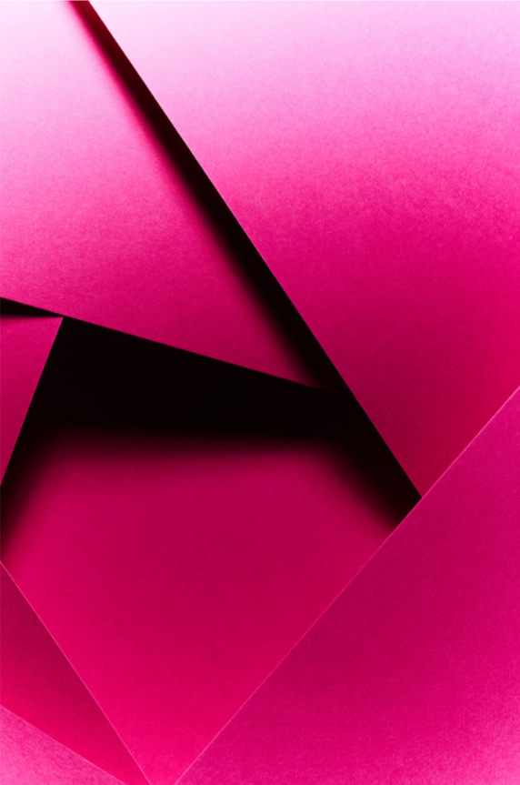 A bright pink geometric pattern that looks like layered paper forming a circle in the middle