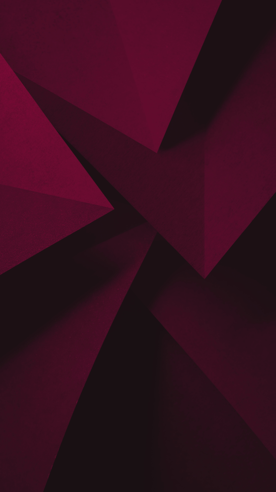 a dark and shadowy maroon background of paper edges and folds