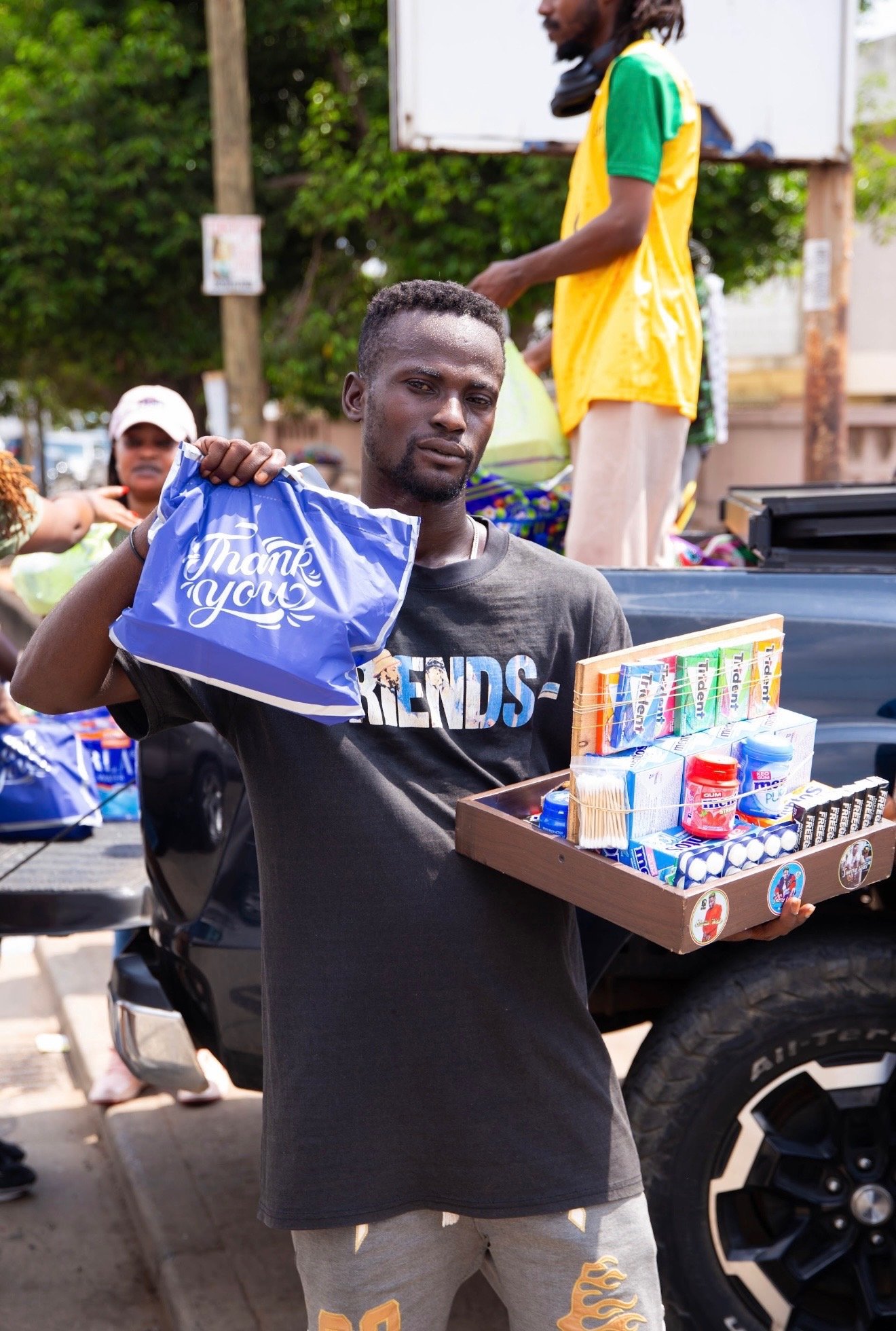Un-housed man holds up donations.