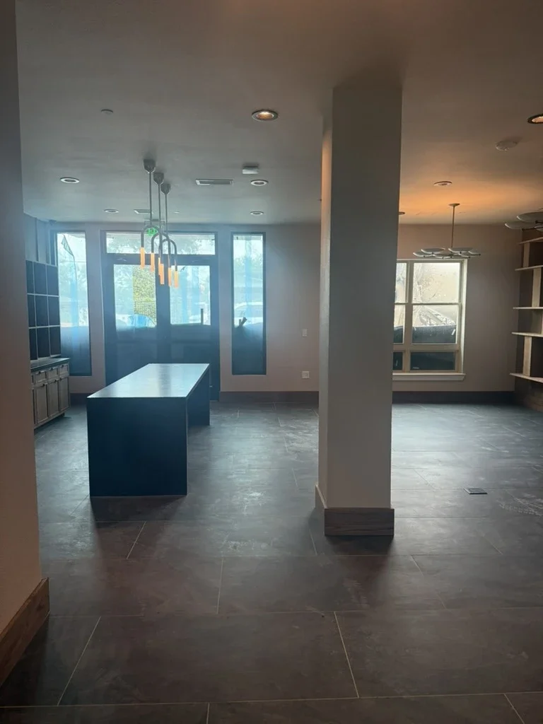 Lobby at The View in Frisco's Rail District with slate tile floor, dark island and structural column. Designed by Artbuckle & Co.
