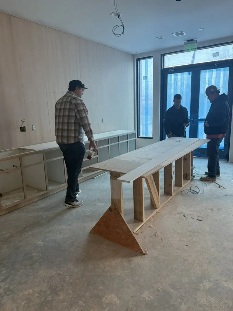 Team reviewing a custom island and cabinetry in progress at The View in Frisco's Rail District. Designed by Artbuckle & Co.