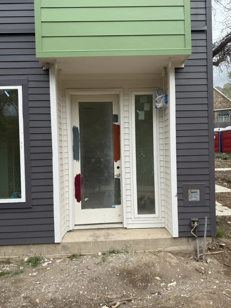Exterior entry door and building facade with test paint swatches during color selection for Gateway Park in Dallas, TX, specified by Artbuckle & Co.