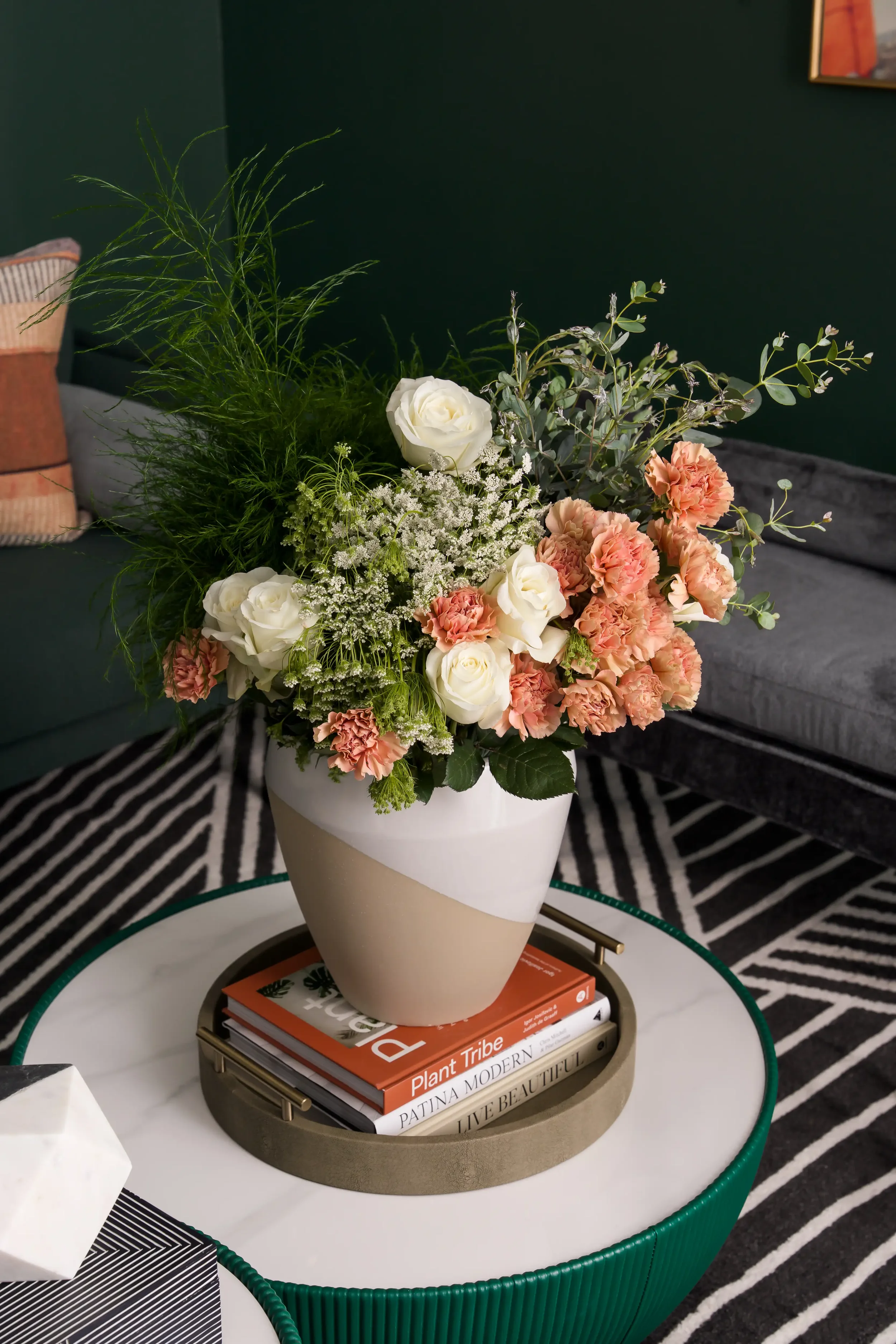Close-up of a floral vase on a round coffee table in the resident lounge at East 9th in Dallas, Texas, designed by Artbuckle & Co.