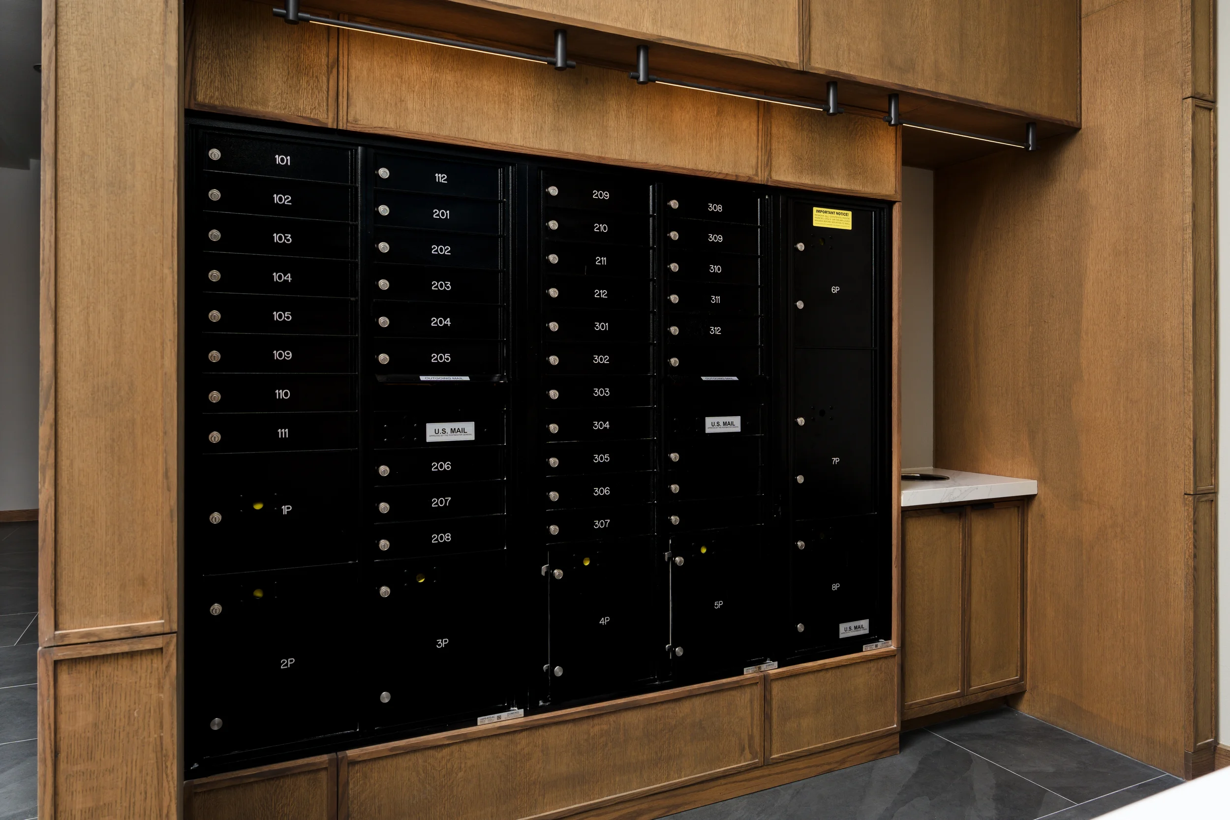 Black parcel lockers framed in oak at The View in Frisco's Rail District.