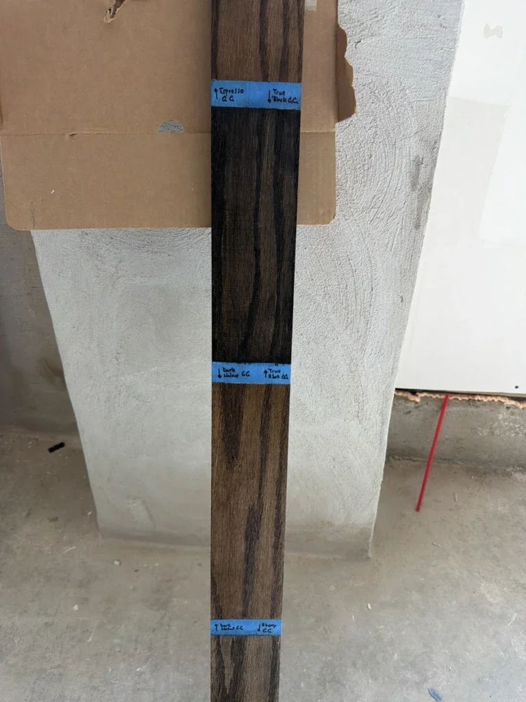 Dark wood stain sample marked with blue tape on site at The Platform in Frisco, TX. Designed by Artbuckle & Co.