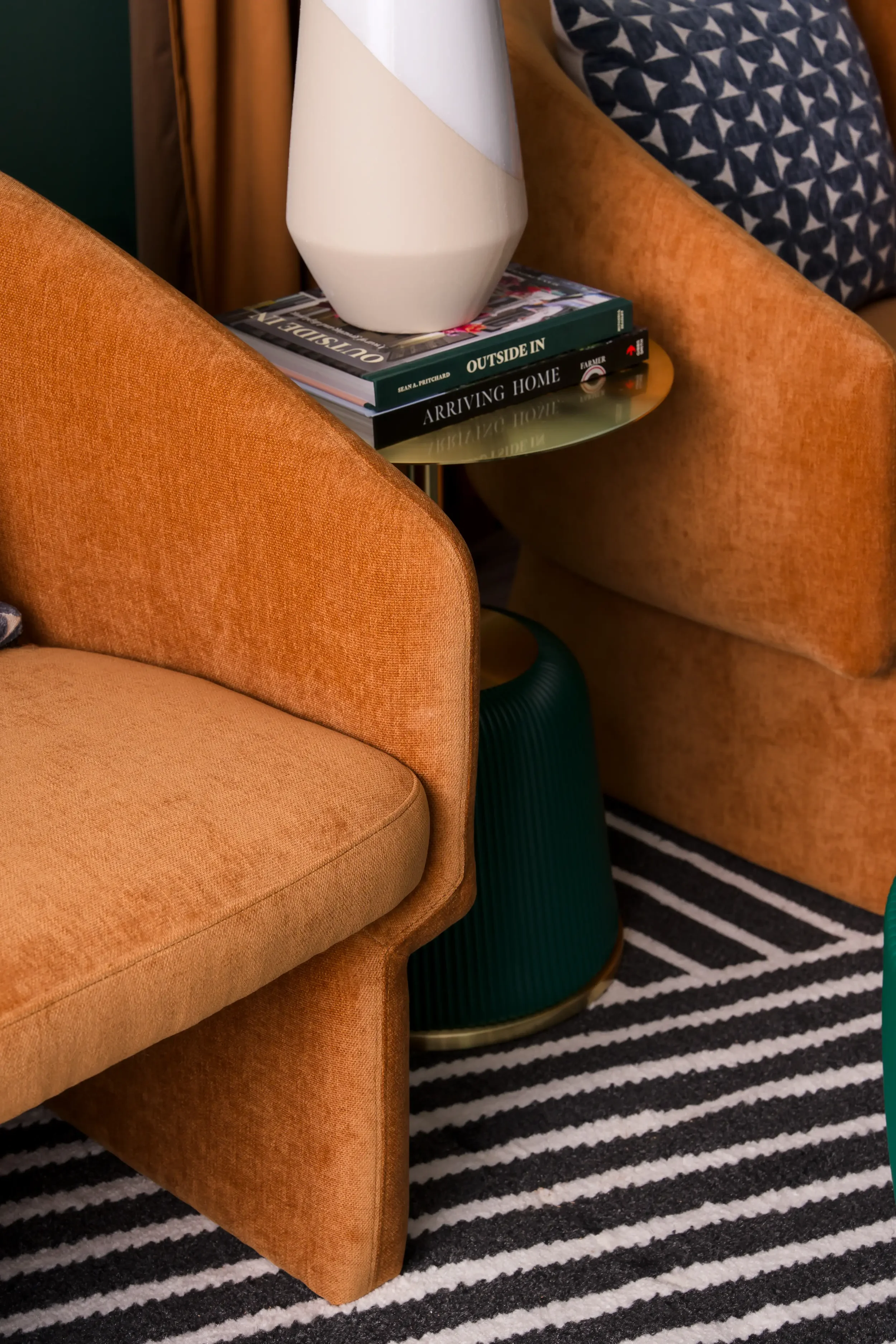 Detail of a cognac velvet lounge chair, green side table, and patterned pillow at East 9th in Dallas, TX, designed by Artbuckle & Co.