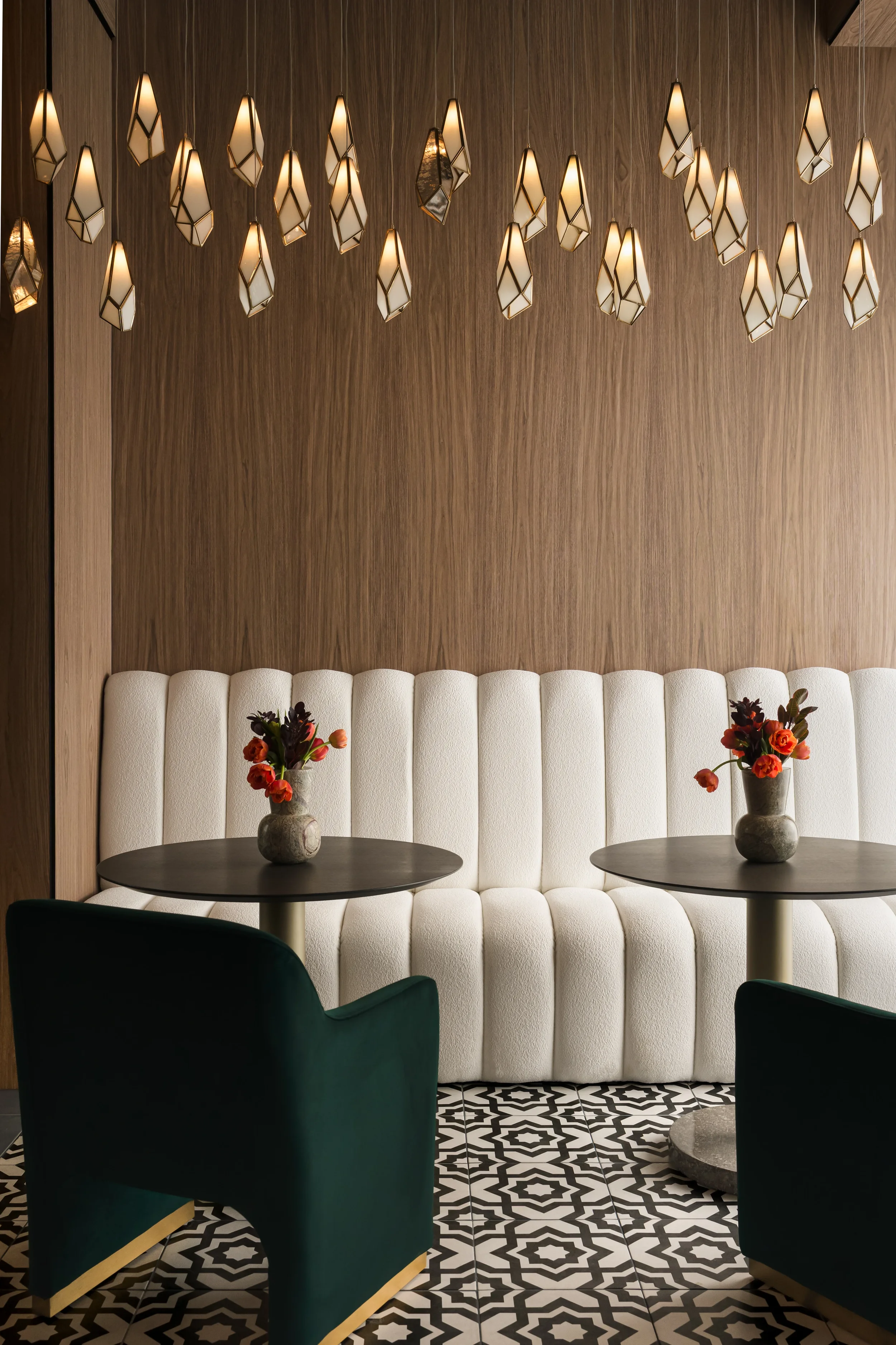 Custom channel-tufted banquette with faceted glass pendants at The Platform in Frisco, TX. Designed by Artbuckle & Co.
