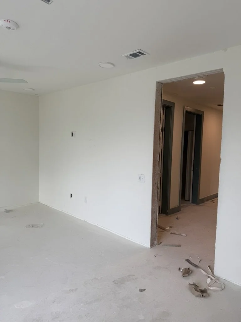 Raw drywall construction phase in the leasing entry corridor at East 9th in Dallas, Texas, during space planning by Artbuckle & Co.