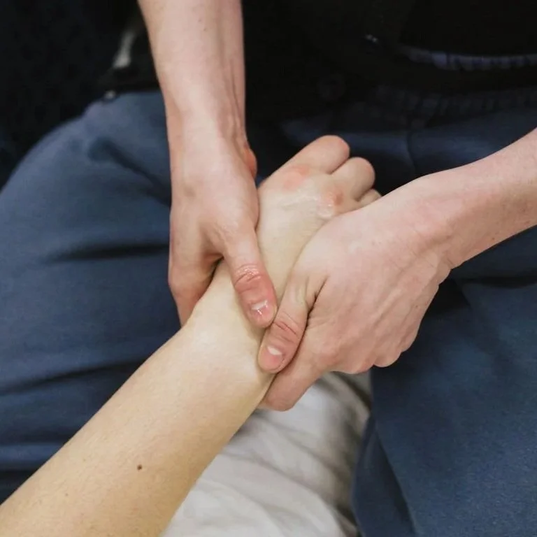 Person receiving a hand massage from another person.