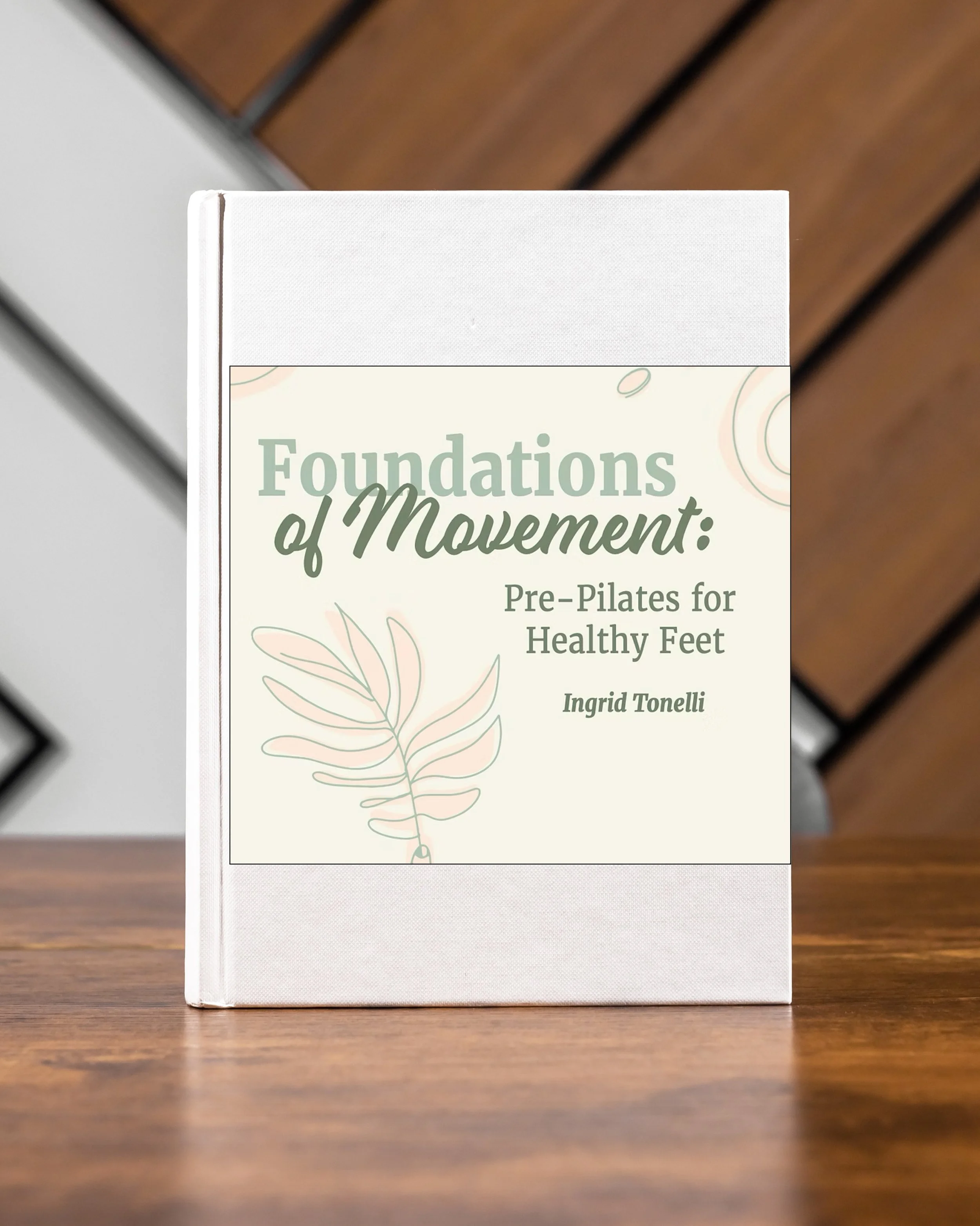 Book titled 'Foundations of Movement: Pre-Pilates for Healthy Feet' by Ingrid Tonelli on a wooden table.