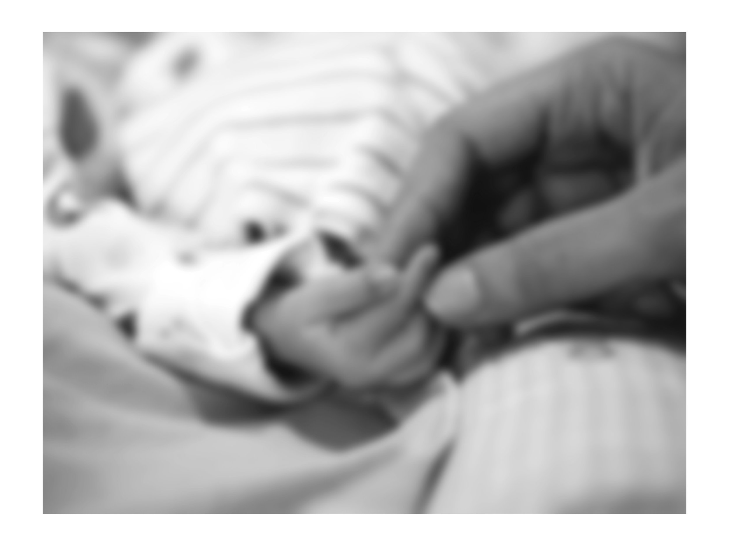 A person holding a newborns hand and fingers