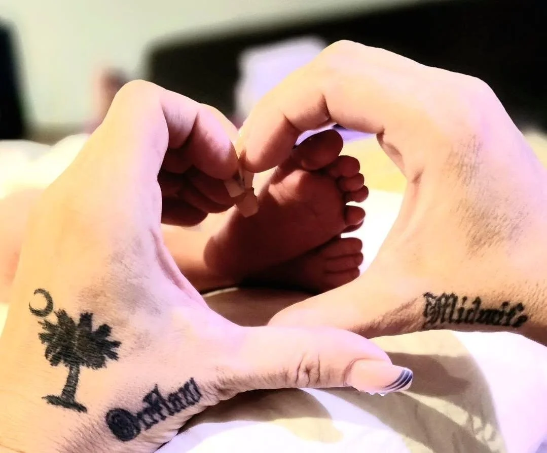 Hands forming a heart shape with tattoos