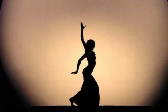 Silhouette of a person in a dance pose against a gradient background.
