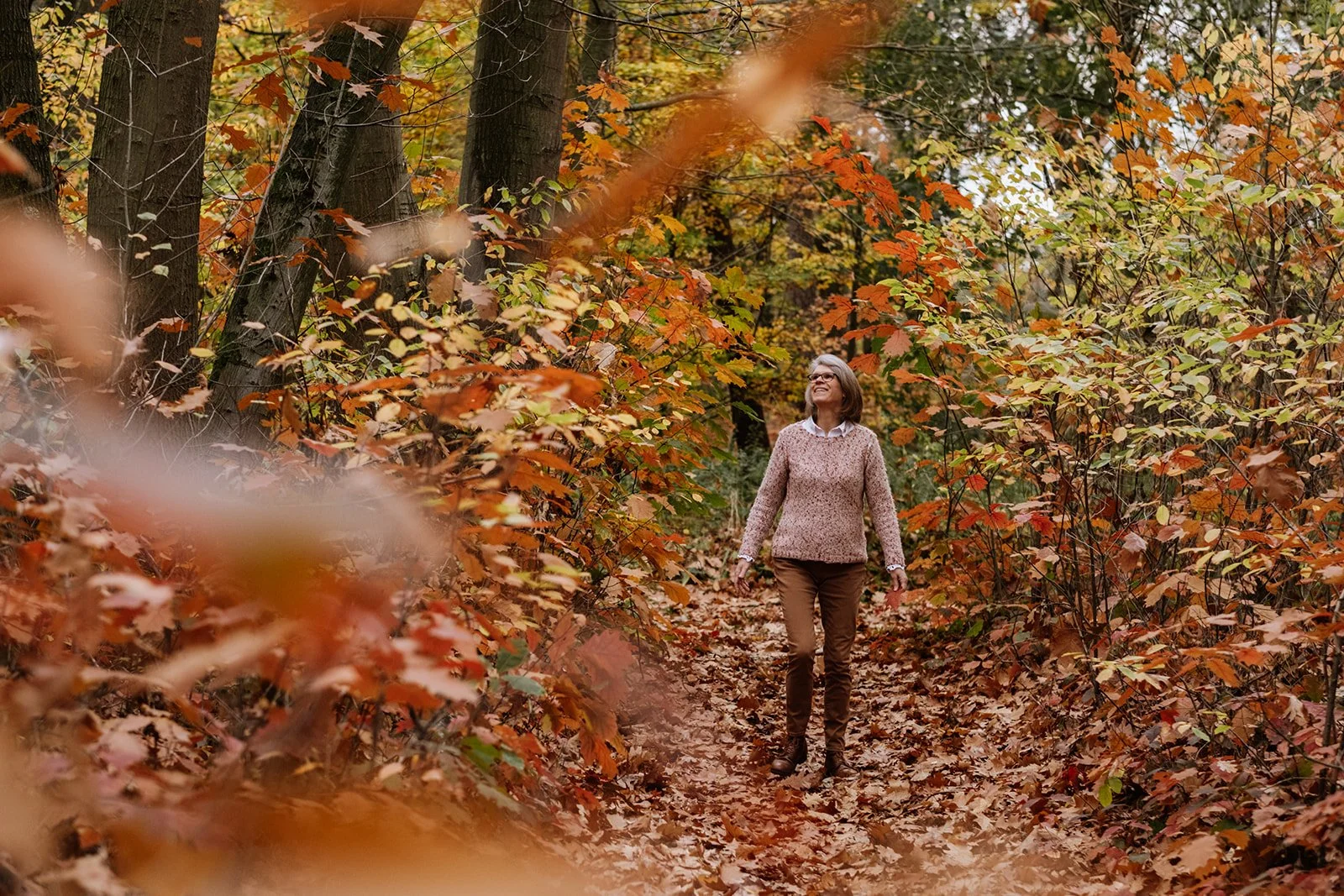 Vrouw wandelt in het bos. Het is herfst.