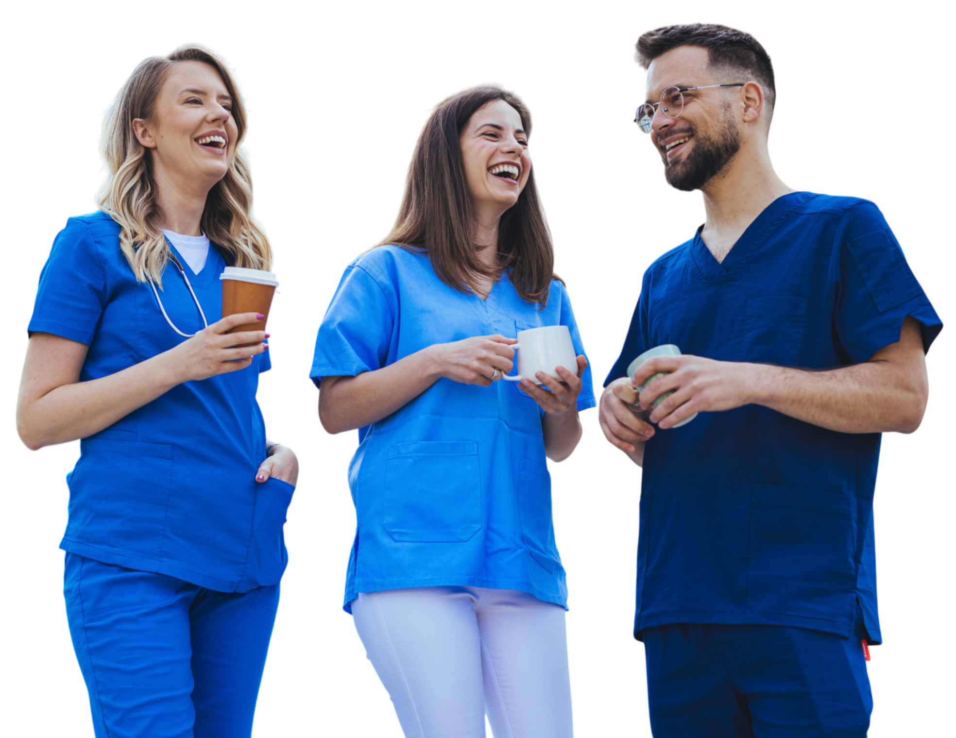 Three healthcare professionals, two women and one man, in blue scrubs, standing outdoors and smiling while chatting and holding coffee cups.