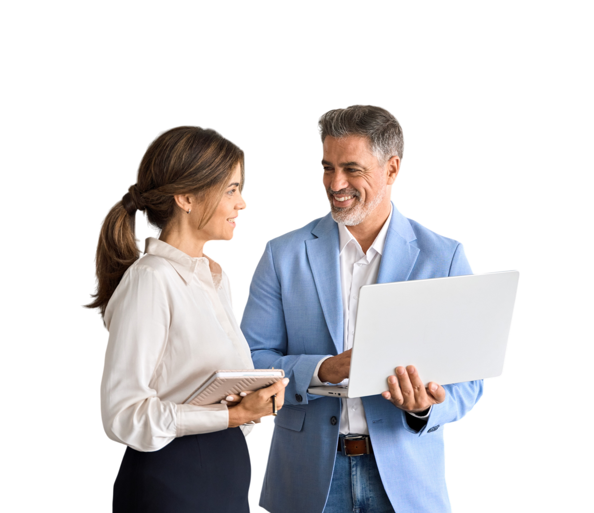 A man in a light blue blazer holding an open laptop and smiling at a woman holding a notebook. They are engaged in a conversation.
