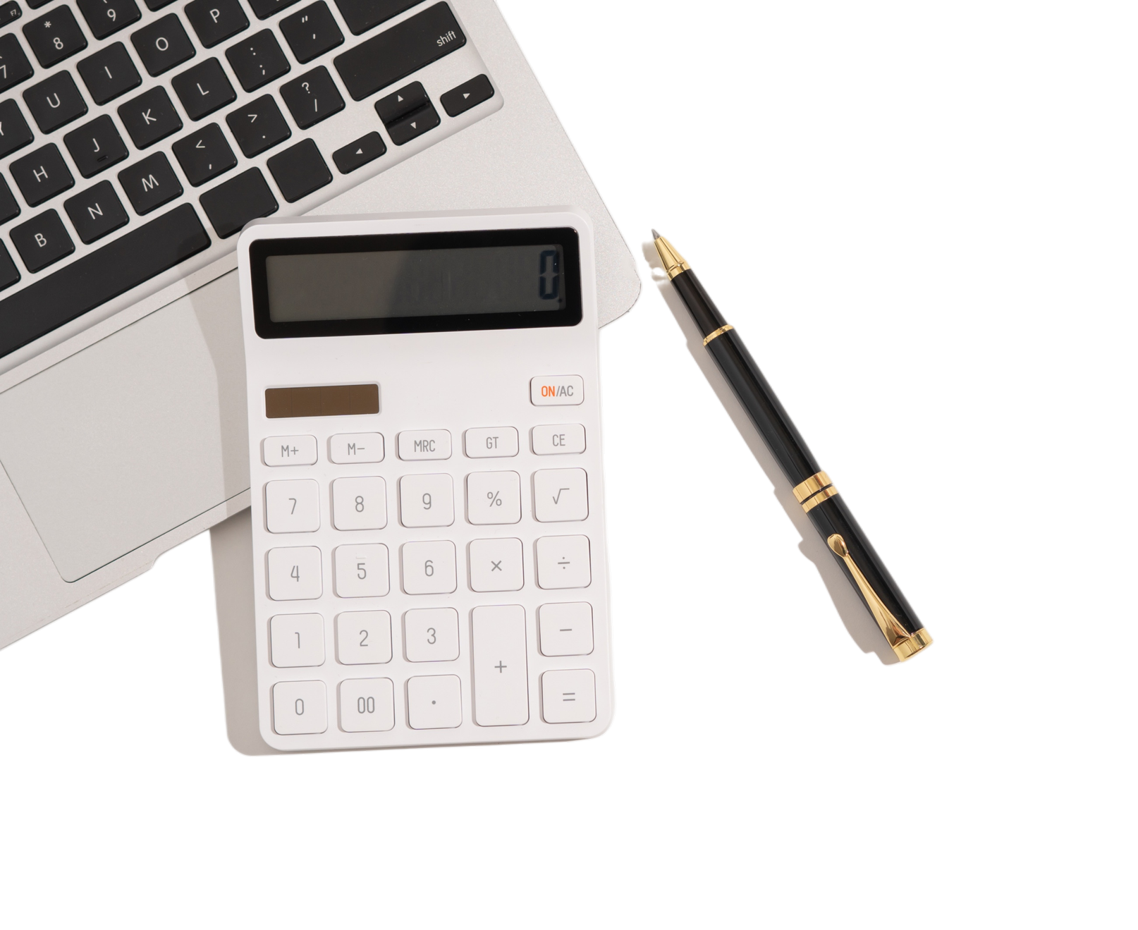 A desk setup with part of a silver laptop, a white calculator, a black fountain pen with gold accents, and a black background.