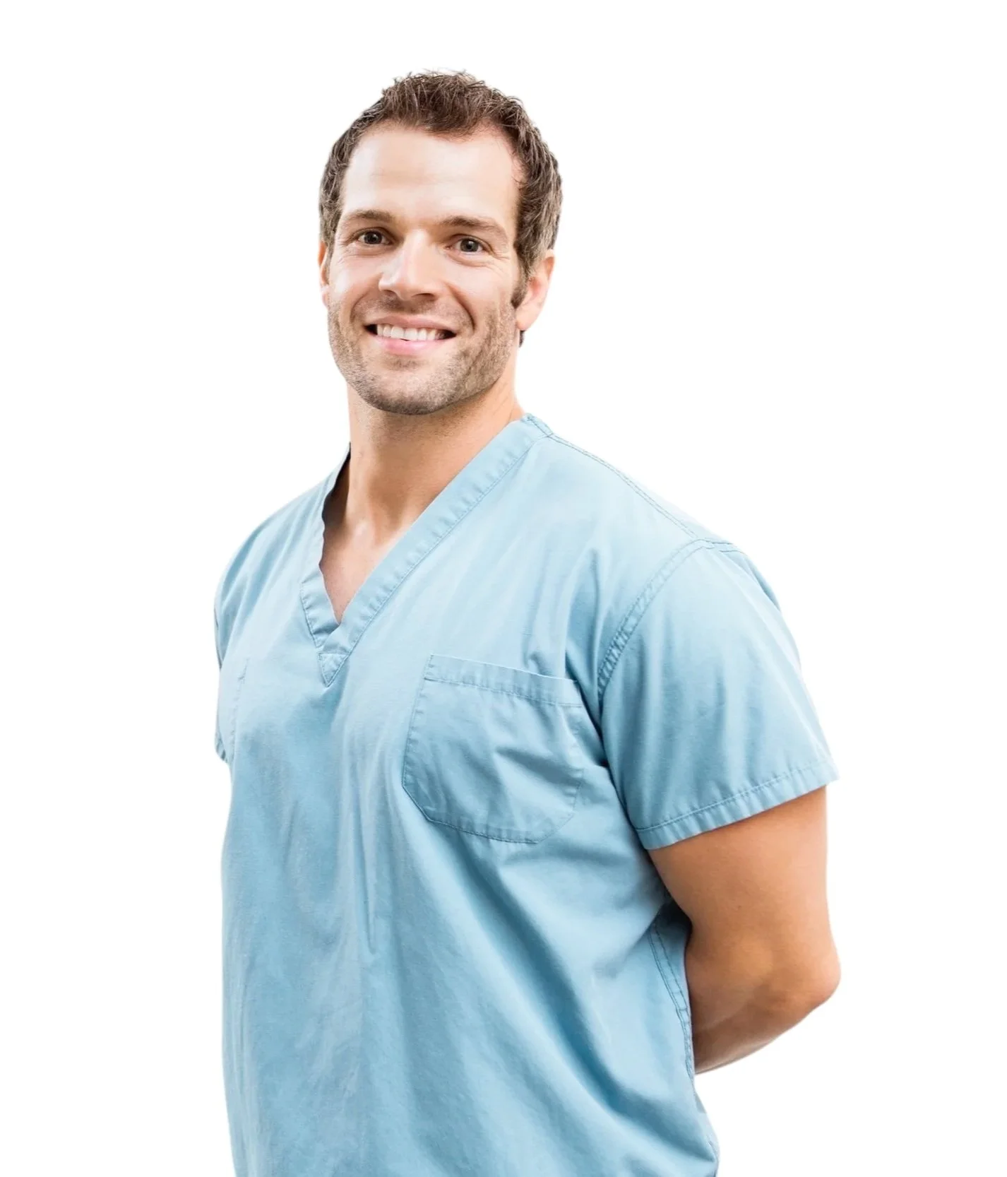 A male healthcare professional wearing light blue scrubs, smiling, with his hands behind his back against a white background.