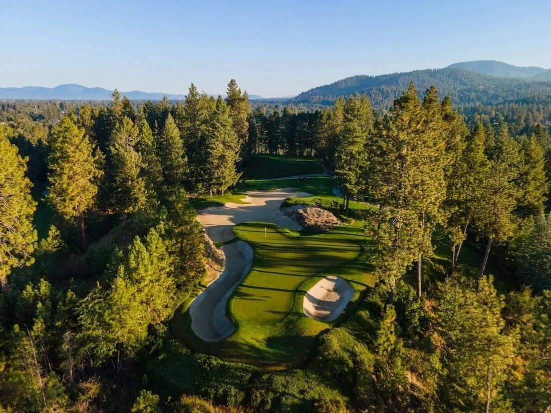 Aerial view of a short hole tucked among trees at the Coeur d’Alene Resort Golf Course.