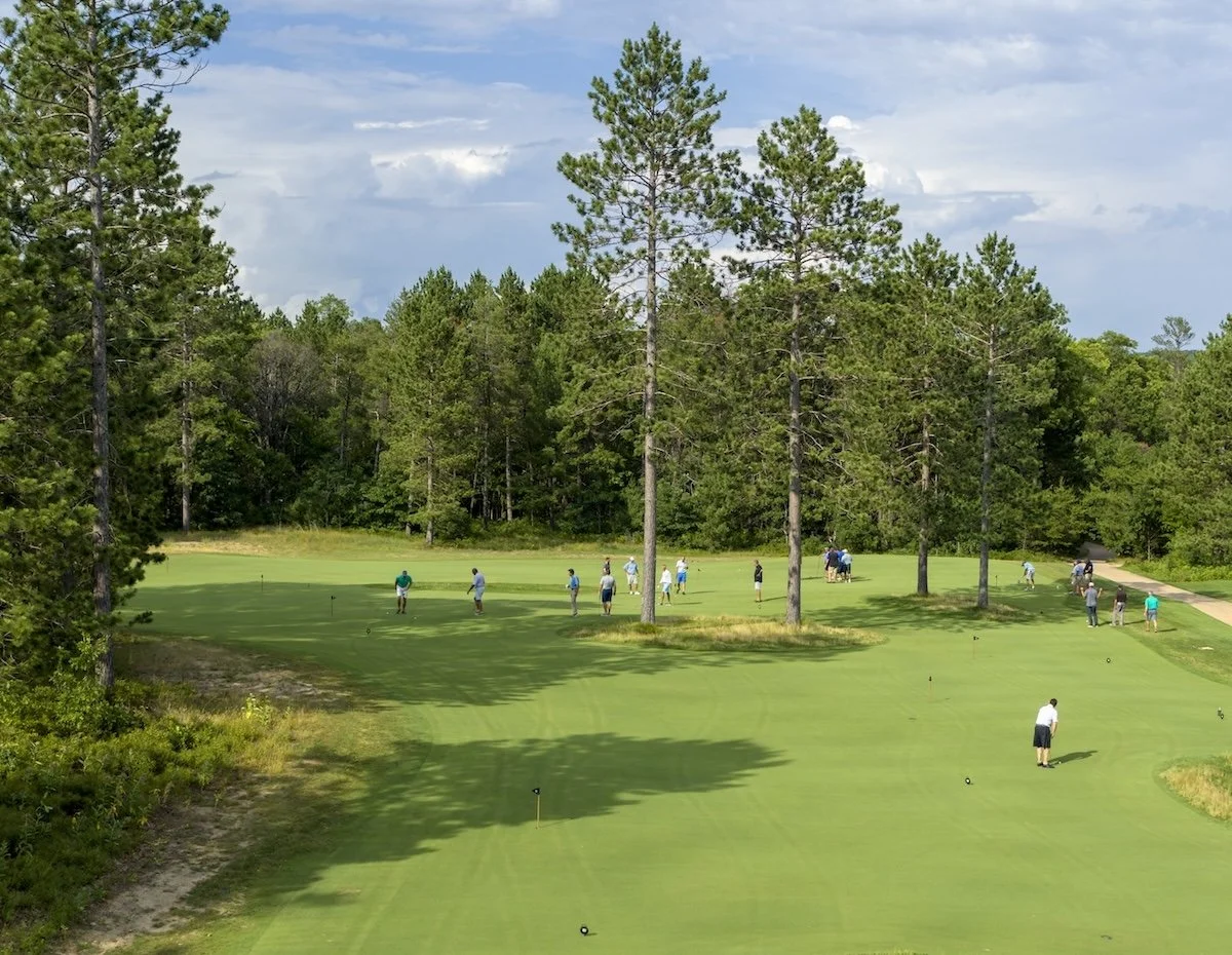 Golfers gathering at the Hilltop Putting Course as the day winds down at Forest Dunes
