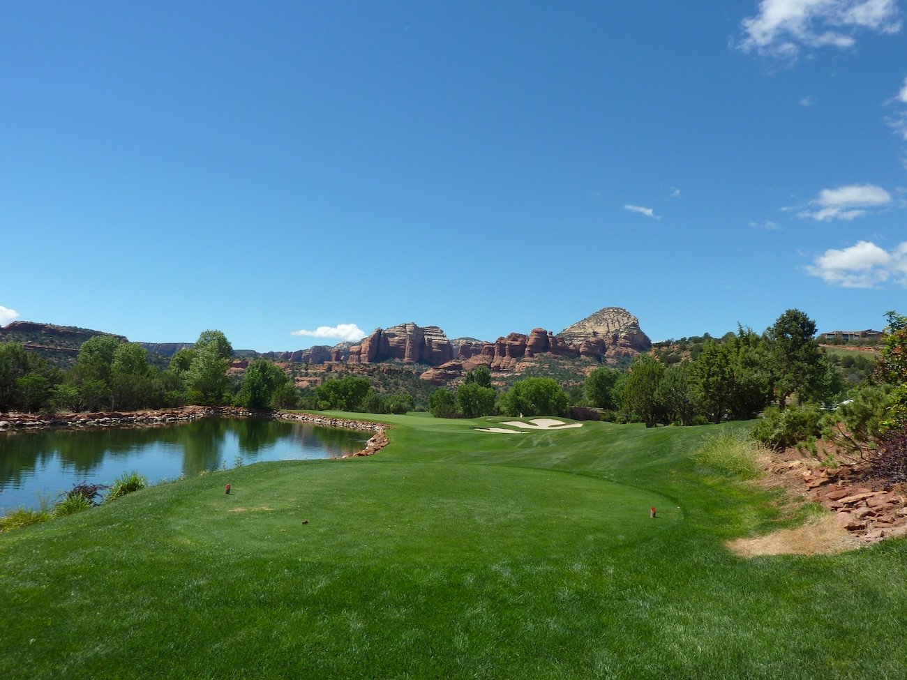 Par-3 tee shot at Seven Canyons Golf Course with dramatic desert and canyon backdrop