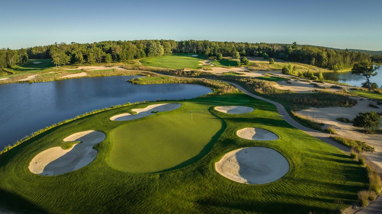 Bunkers and a lake protect the green on a hole on Tom Weiskopf's Forest Dunes course
