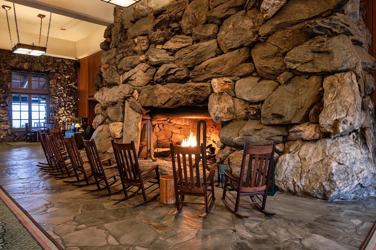 Rocking chairs facing the massive stone boulder fireplace in the Great Hall of the Omni Grove Park Inn.