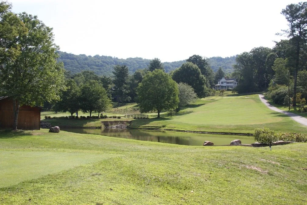 A pond fronts the fairway of a tree-lined hole at The Omni Grove Park Inn Golf Course