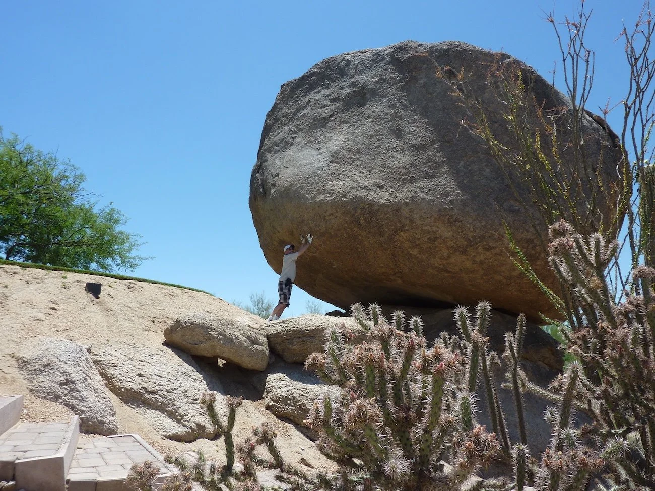 Holding up a large boulder on a golf course in an optical illusion photograph