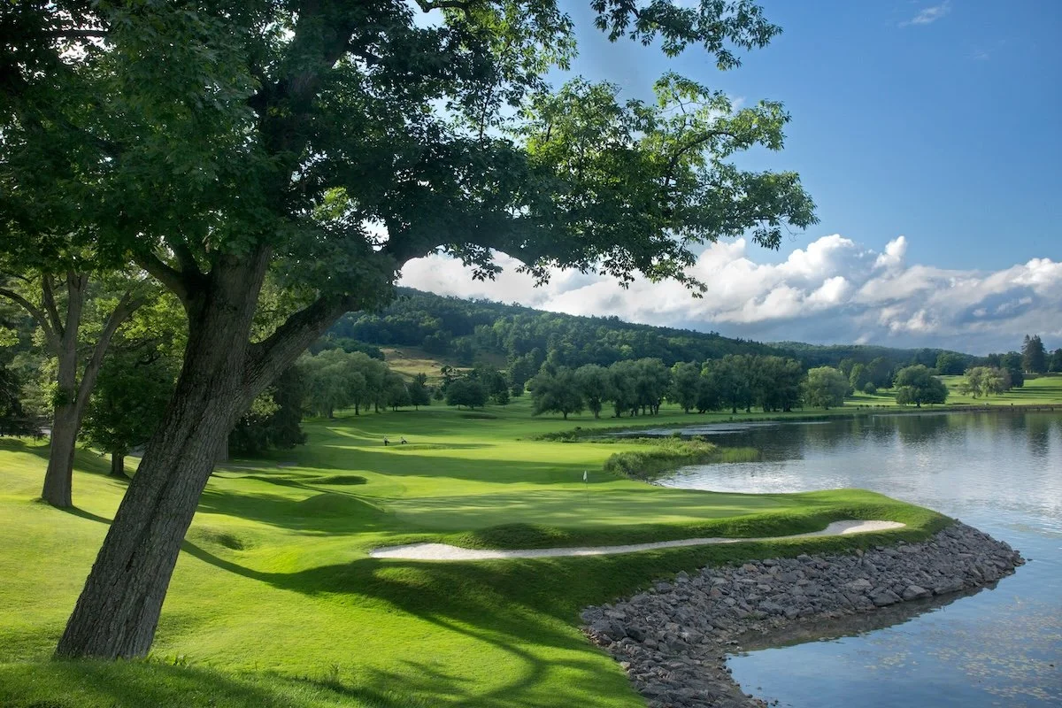 Trees shade the green on Leatherstocking's 18th, which traces the lake from tee to green.