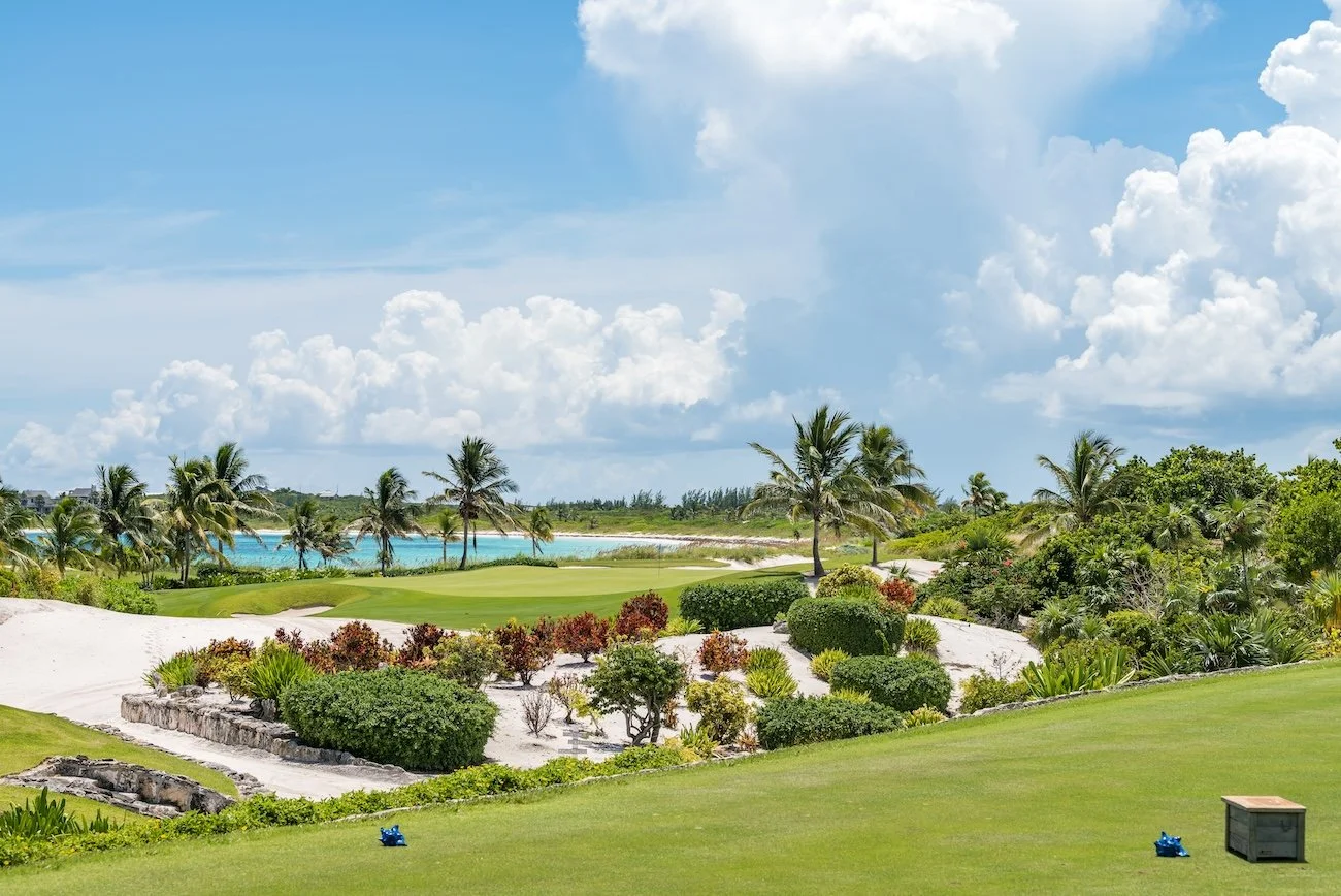 Putting surface at The Abaco Club framed by coastal vegetation and ocean views