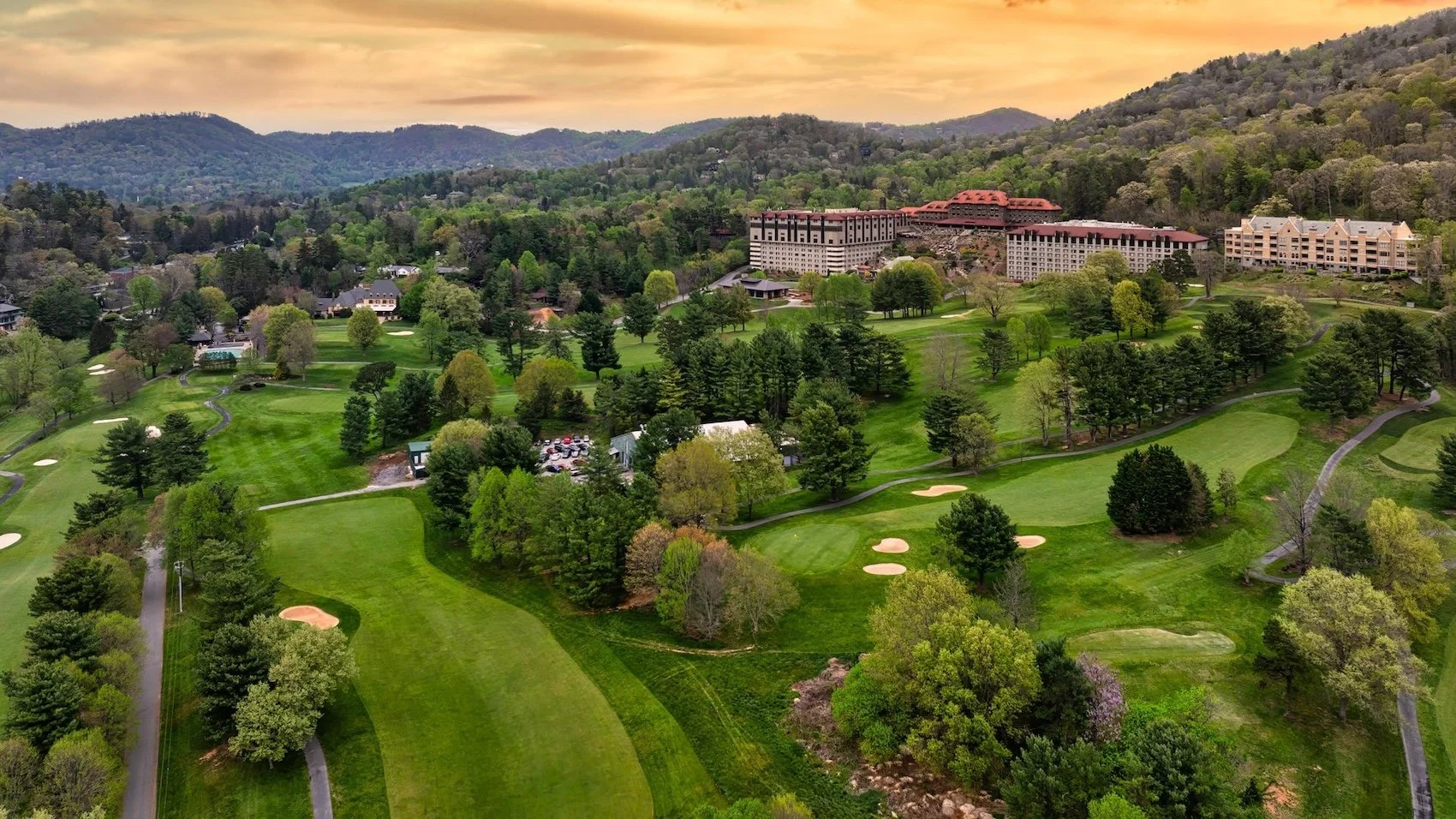 Aerial view of the Omni Grove Park Inn and golf course with the Blue Ridge Mountains in the background