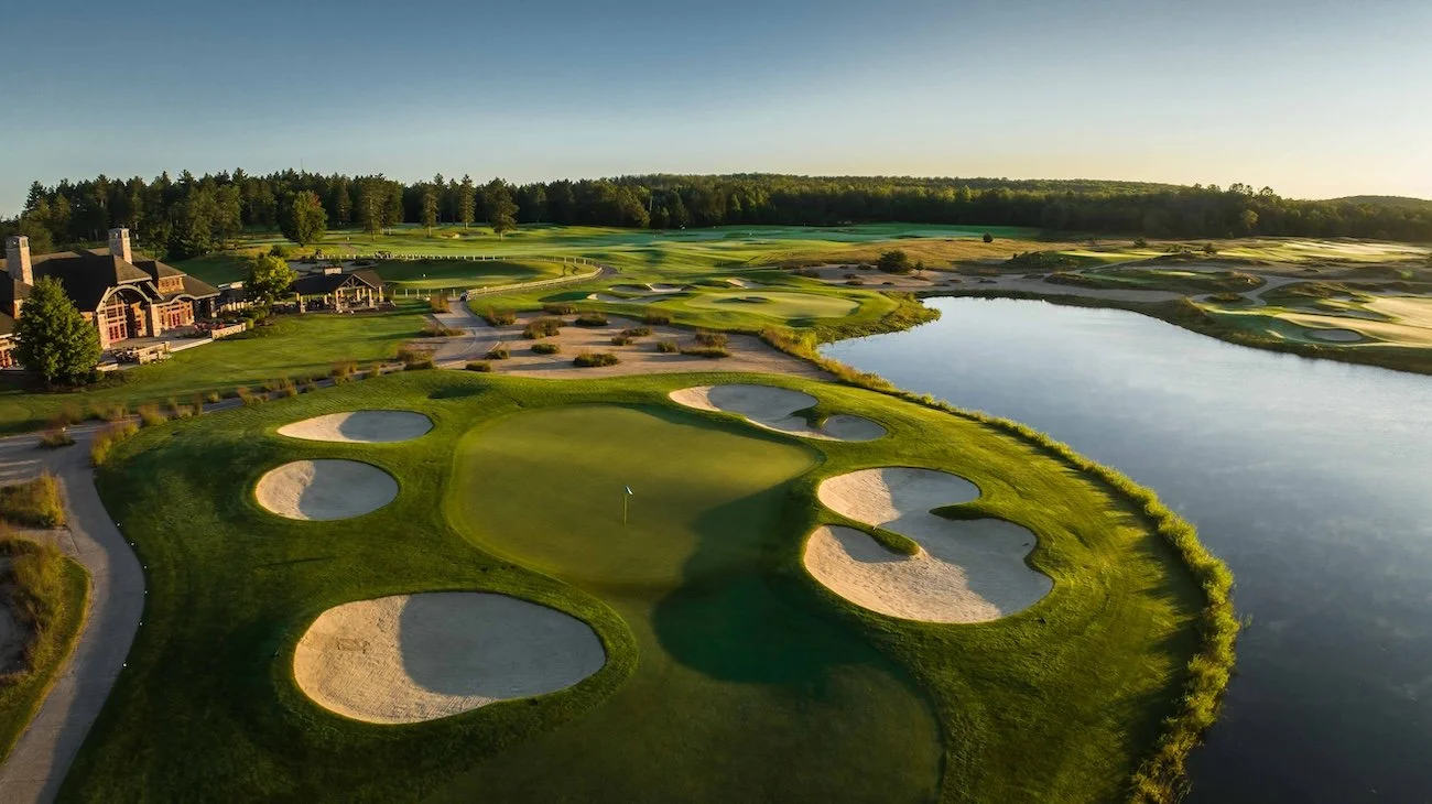 Immaculately groomed bunkers surround a two-tiered green near the clubhouse at Forest Dunes Golf Resort