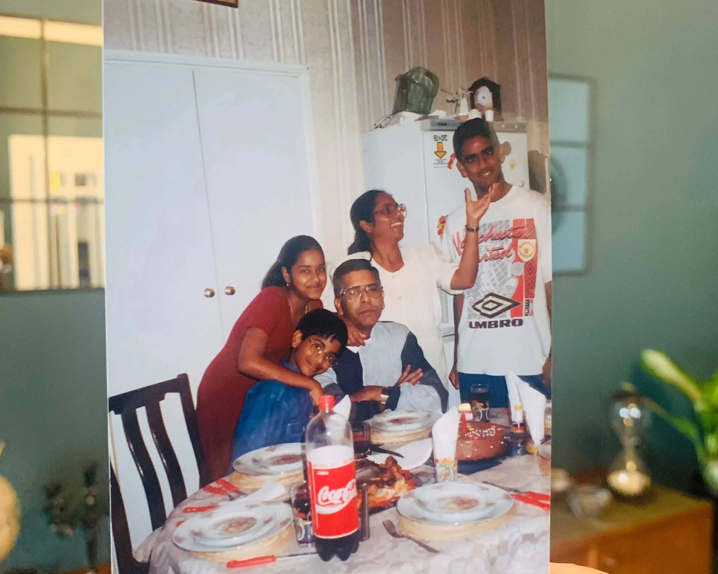 An old colour image of a family in a dining room is overlayed the reality of the same space to show how the before and after interplay, the image is lined up to try and show the space has evolved