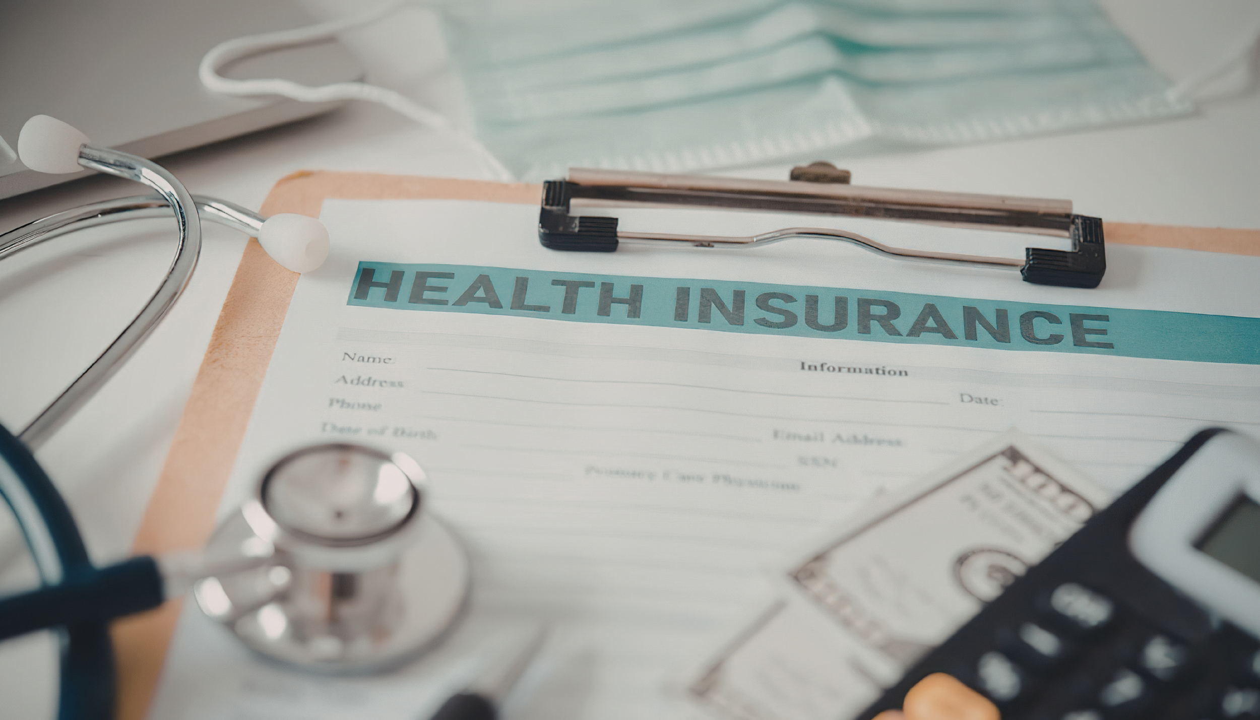 A healthcare setting with a health insurance form, stethoscope, and medical supplies including a face mask and a medical instrument on a table.