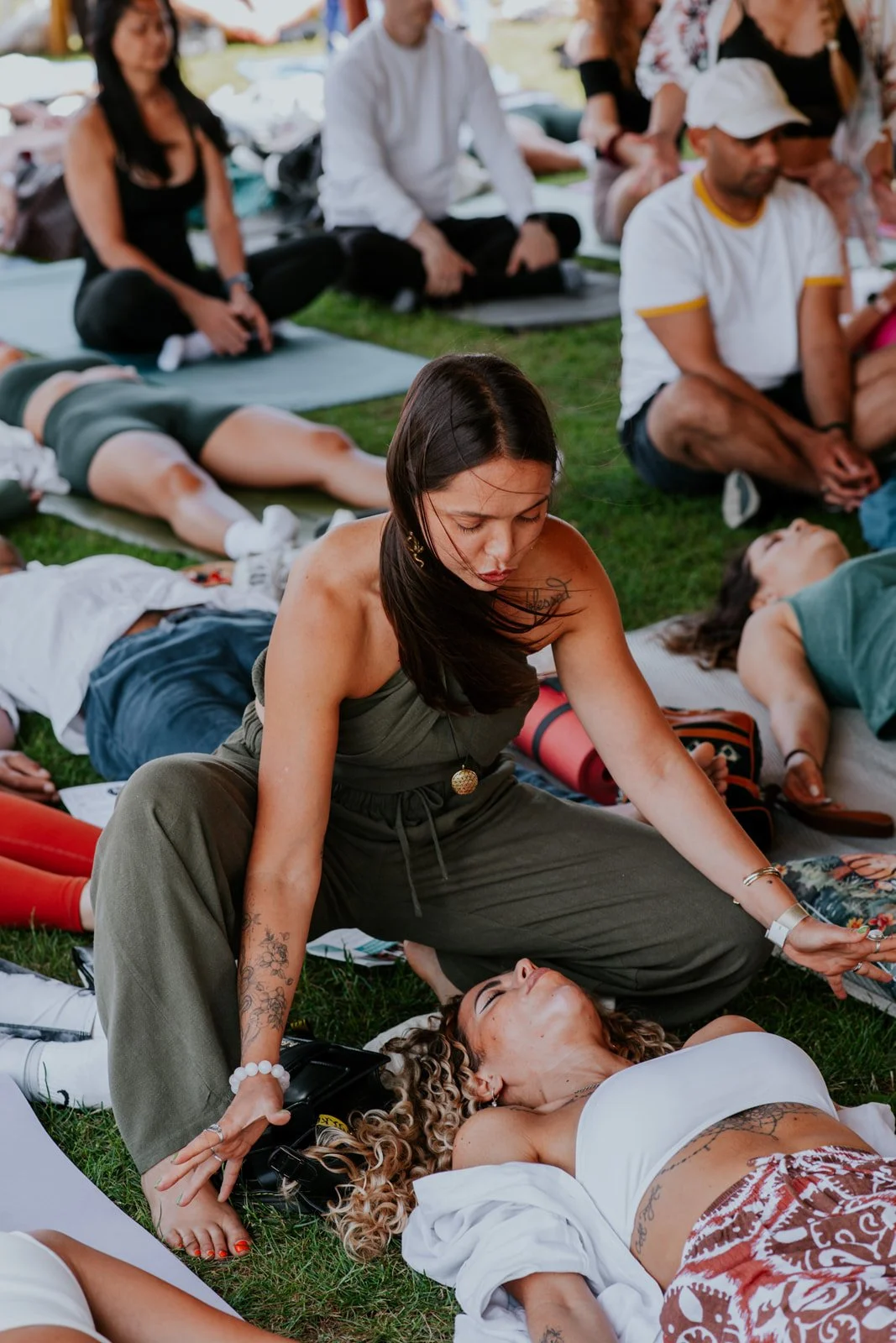 Suia working on a client lying down in a group event