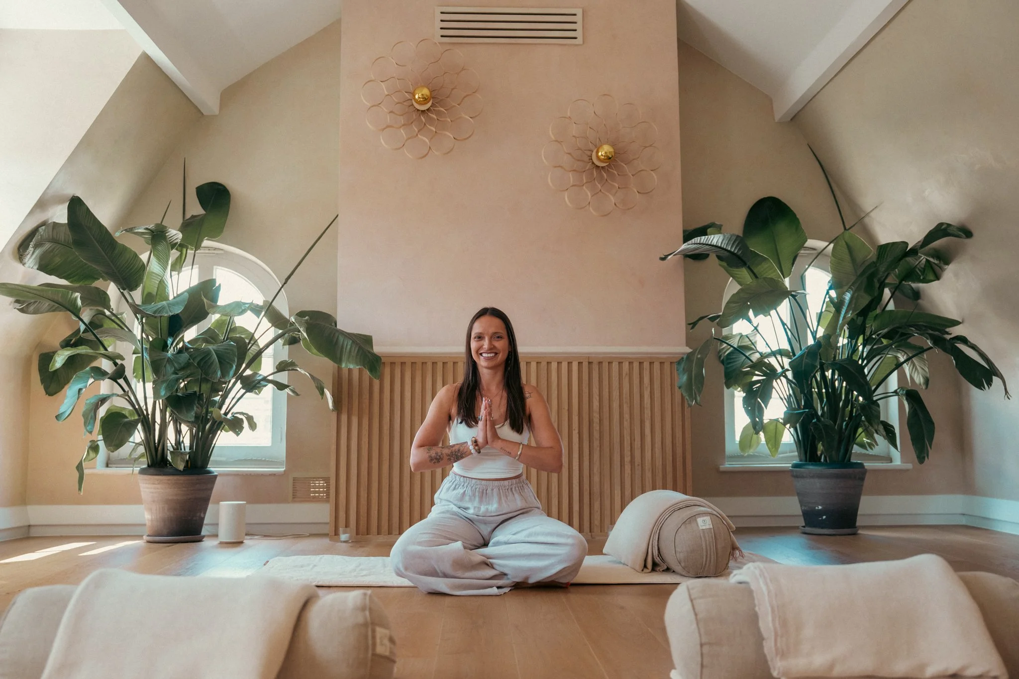 Suia with hands joined in prayer smilng in a clean room