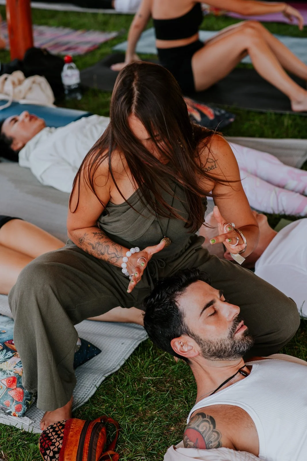 Suia woriking on client lying down in group ceremony in healing