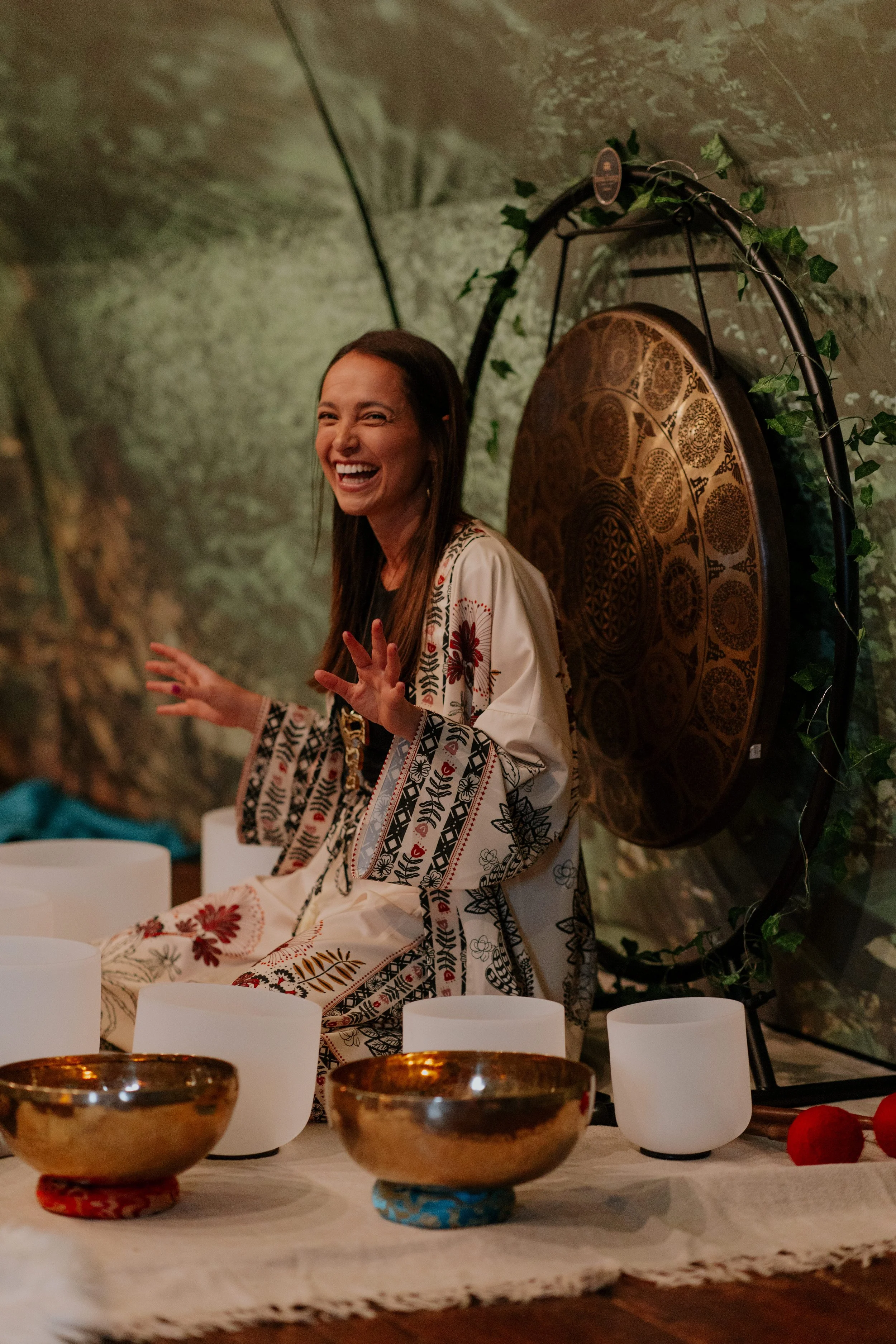 Suia smiling surrounded by singing bowls