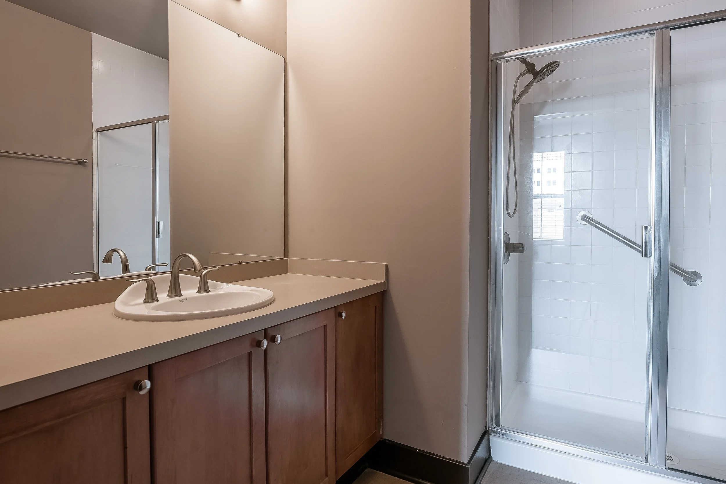 Bathroom with a double sink vanity and a glass shower stall