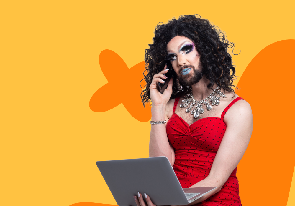 A person with beautiful makeup and curly hair, wearing a red polka dot dress, holding a laptop and talking on the phone, against a colorful orange and yellow background.