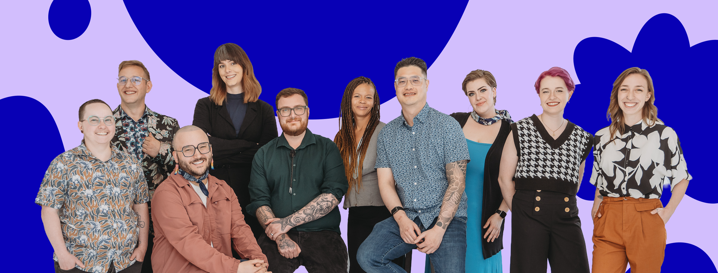 A diverse group of twelve people smiling and standing together against a purple background with abstract blue shapes.